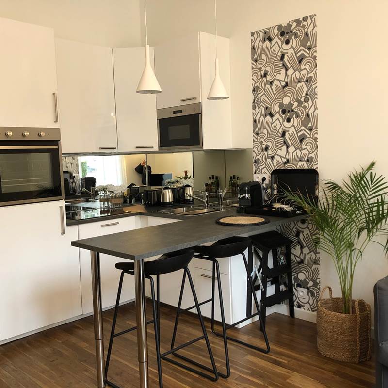 La cuisine équipée s'ouvre sur le salon