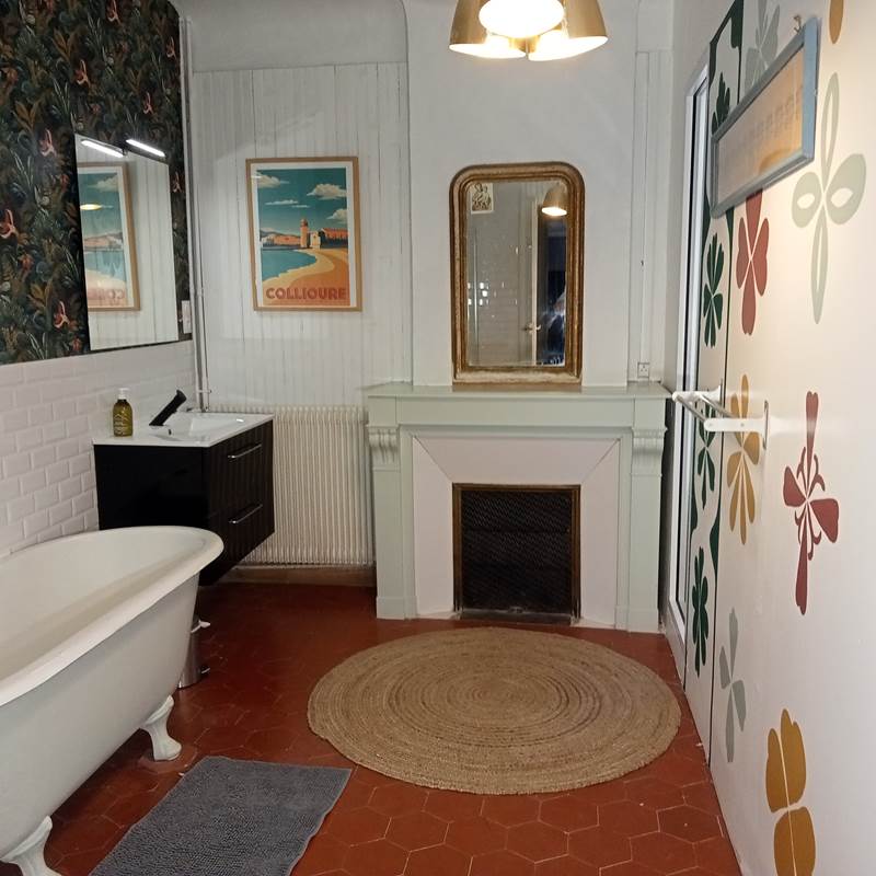 Le Mas Palegry chambres d'hôtes Perpignan - La salle de bain de la chambre n°2 côté jardin. Très spacieuse, avec une magnifique cheminée et un très belle baignoire 19ème. Douche et lavabo. Sol en tomettes anciennes.