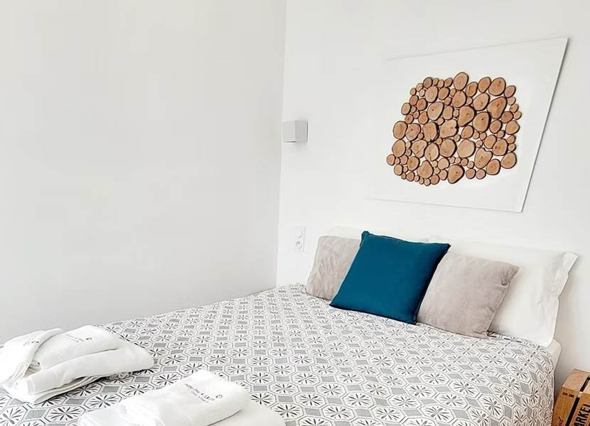 Petite chambre d'hôtes confortable et cosy avec décoration murale en bois naturel.