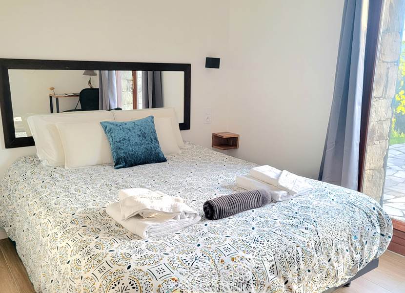 Chambre d'hôtes n°4 lumineuse avec lit queen size et accès direct à une terrasse privée.