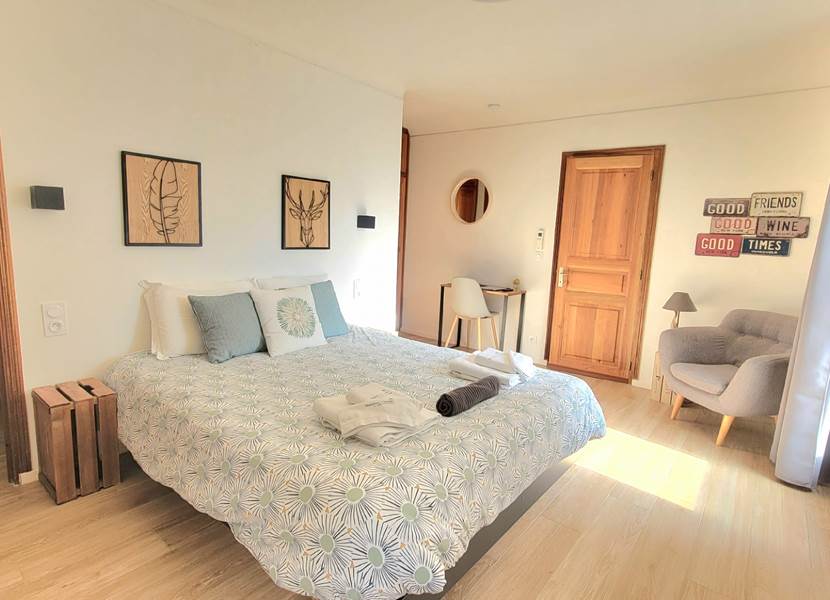 Chambre d'amis 1 spacieuse avec lit double, décoration naturelle et ambiance lumineuse au Domaine Cardu.