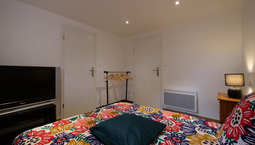 Petite chambre avec porte vers la salle de bain et porte vers le couloir