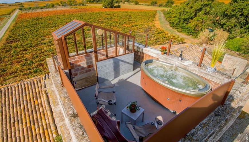 Jacuzzi avec vue panoramique sur les vignes dans une chambre romantique en Occitanie