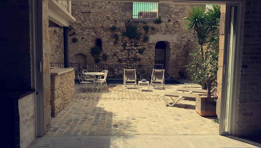 Terrasse de plain-pied pavée avec mobilier de jardin et coin repas extérieur