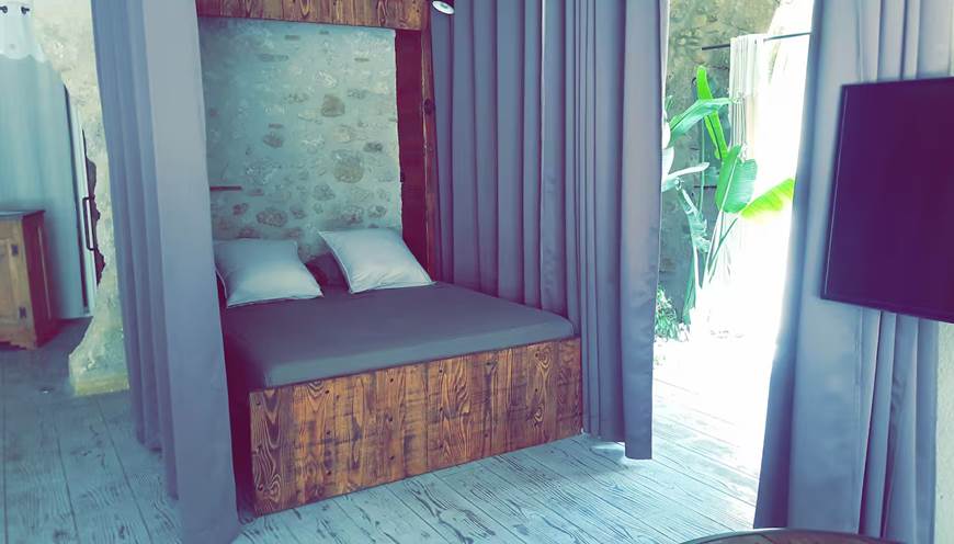 Chambre cosy avec lit 160x200 séparée par un rideau occultant, dans un gîte moderne