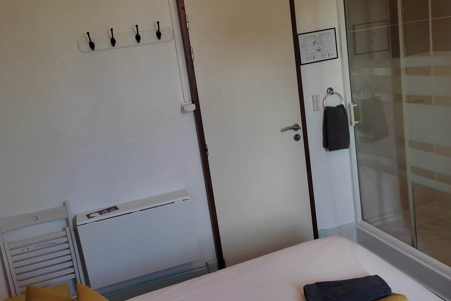 Chambre 5,  lit, douche et serviettes.
