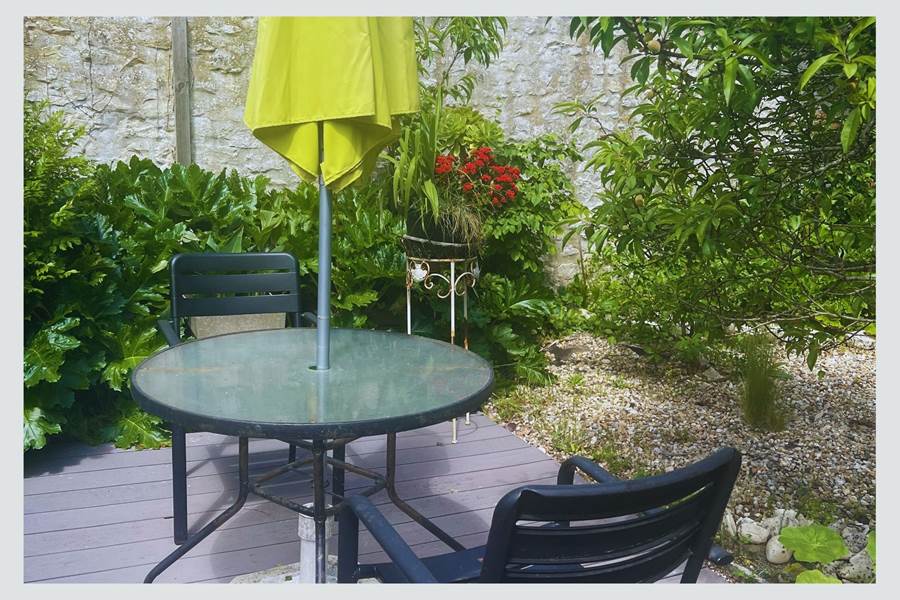 Terrasse fleurie et calme pour vos repas à l’extérieur Entouré de plantes luxuriantes et de murets en pierre, ce petit coin repas est idéal pour savourer l’ambiance douce et typique de l’île de Ré.