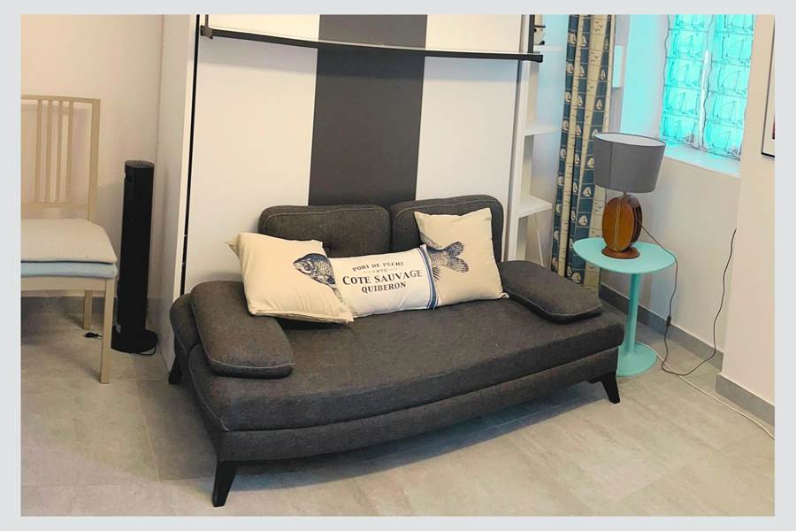 Studio – Coin salon avec charme rétais Ambiance chaleureuse et touche marine dans cet espace modulable en plein centre piéton. Confort assuré pour un séjour paisible à La Flotte
