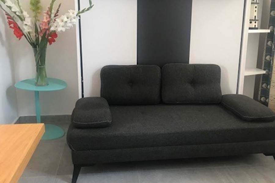 Studio – Coin salon avec charme rétais Ambiance chaleureuse et touche marine dans cet espace modulable en plein centre piéton. Confort assuré pour un séjour paisible à La Flotte