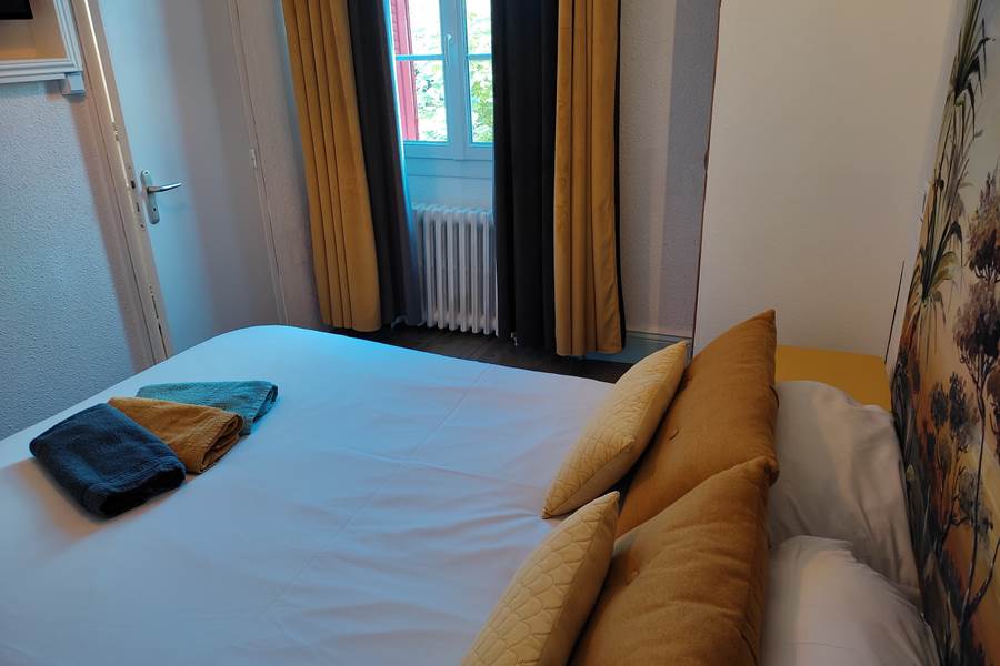 Chambre 5, lit, fenetre et serviettes.