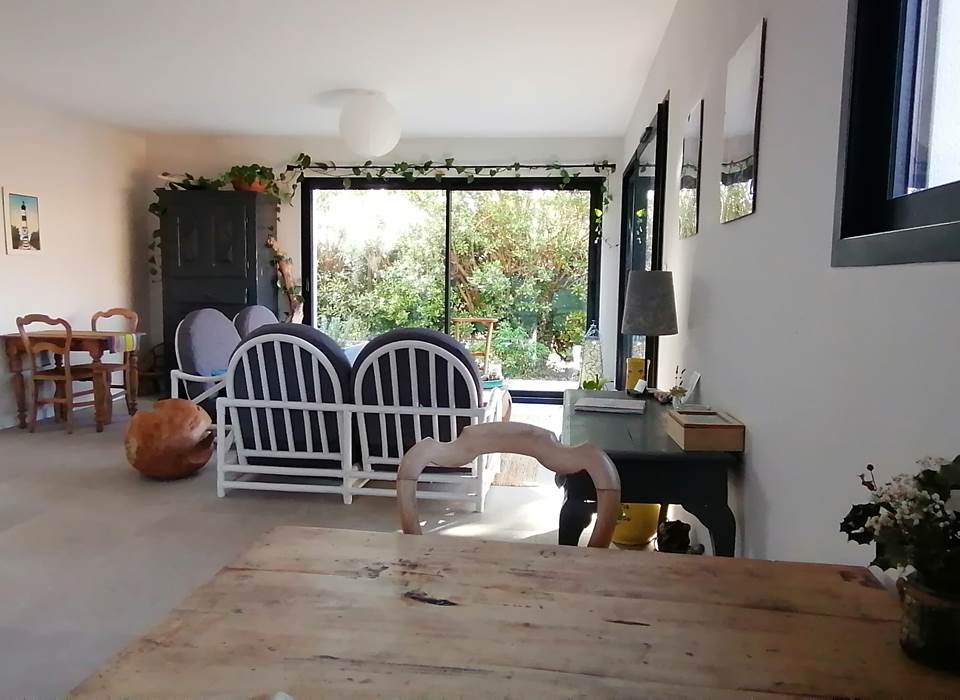 Aux Callunes, le salon réservé aux clients est très lumineux et donne un accès direct aux chambres d'hôtes, à la grande terrasse en bois et au charmant jardin arboré